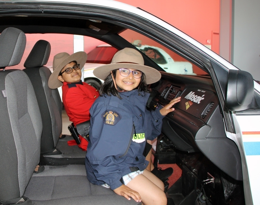 Kids playing inside RCMP vehicle simulator